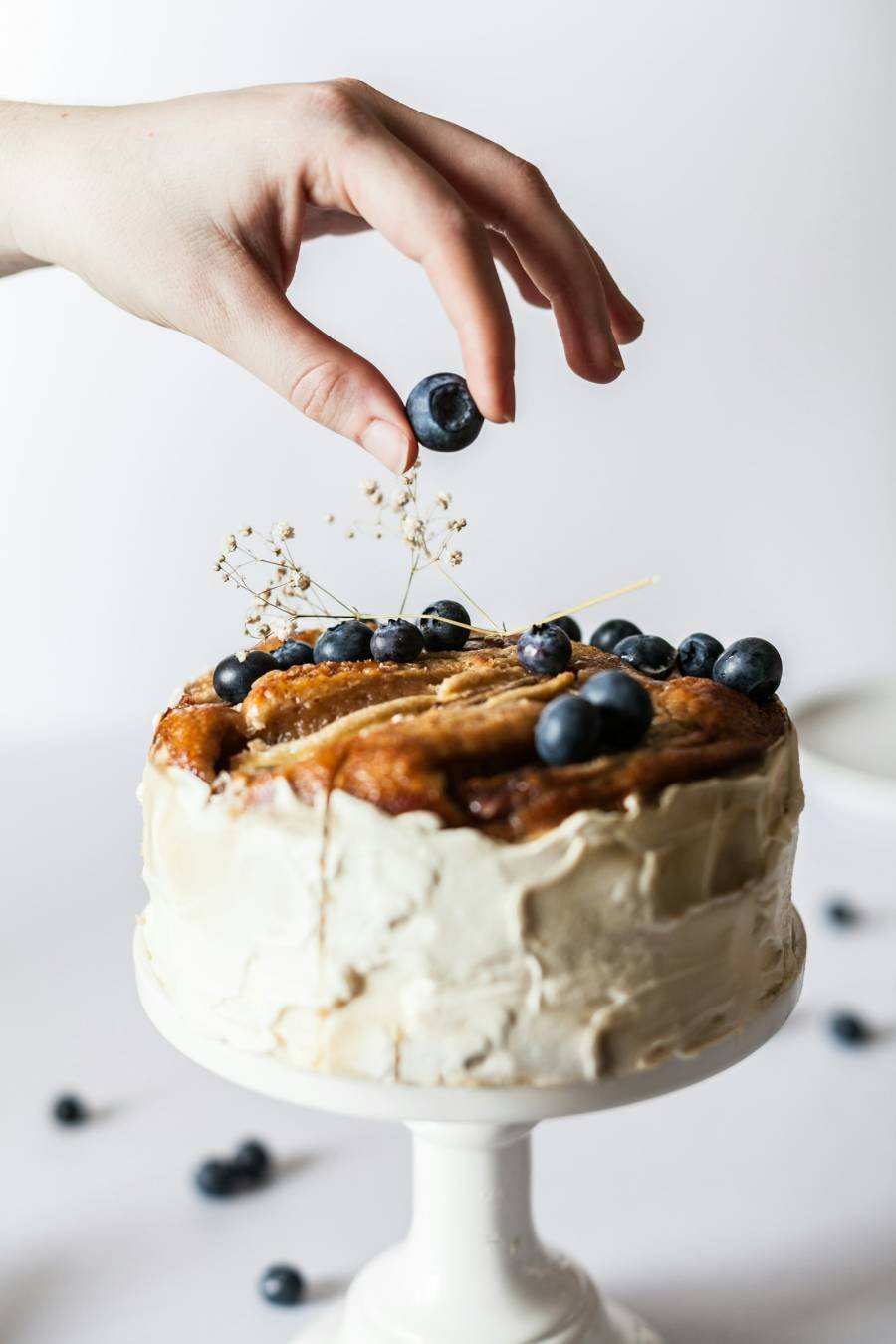 Placing a blueberry on a cake
