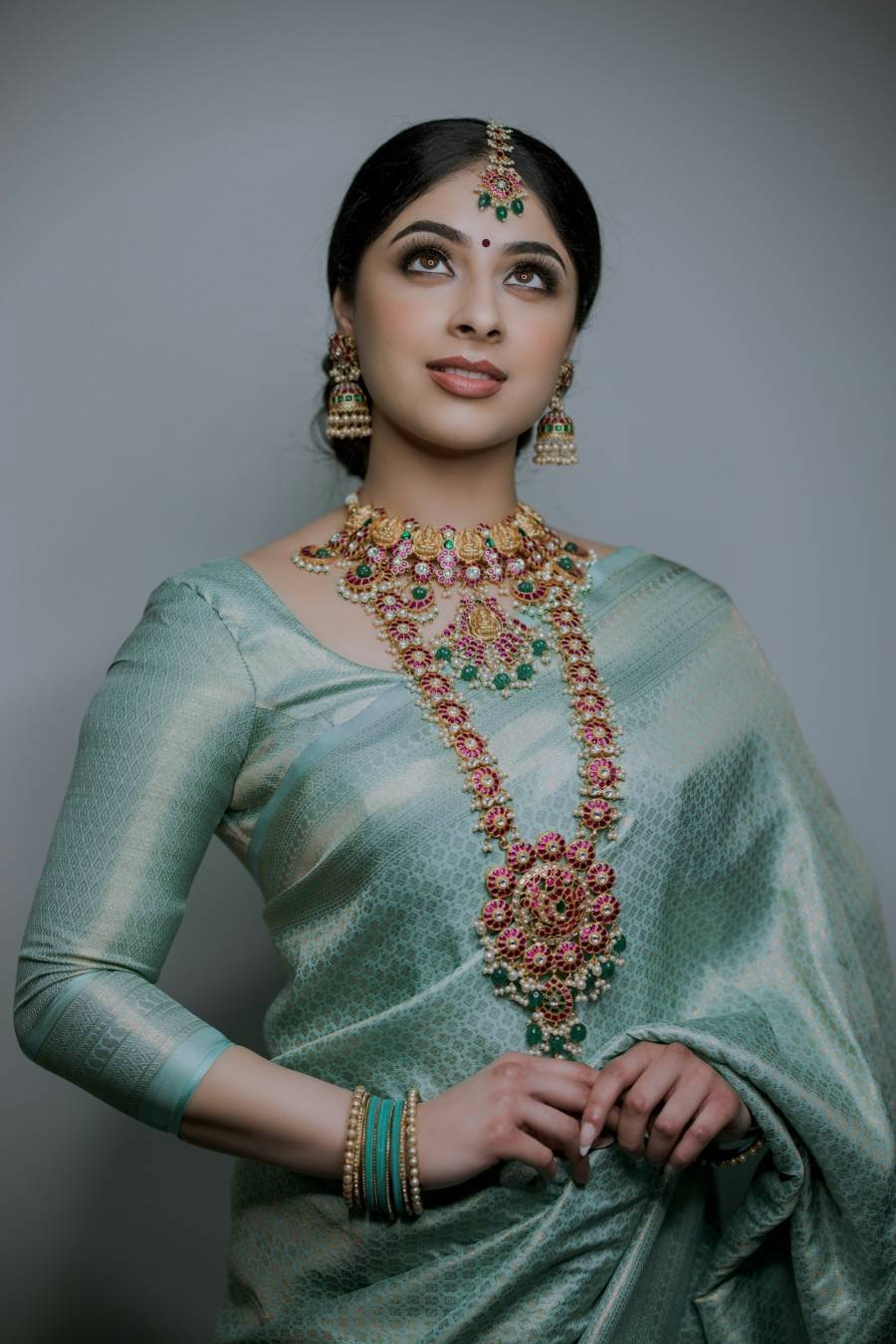 Woman in a green silk saree with gold jewellery